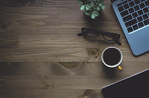 Cozy Workspace Flat Lay with Coffee, Glasses, and Laptop on Rustic Wood HD wallpaper