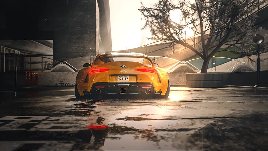 Rear View of a Yellow Toyota Supra Parked on a Wet Urban Street at Sunset HD wallpaper