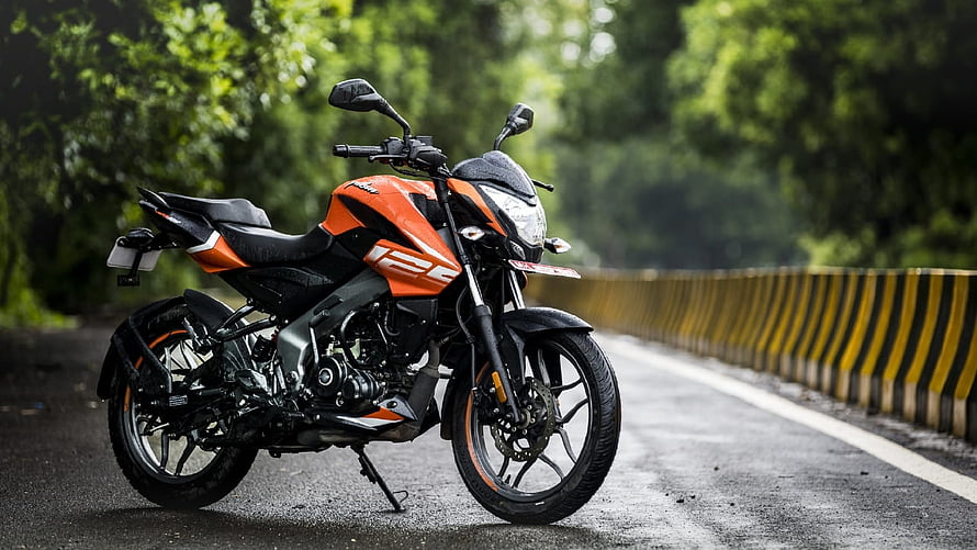 Orange Bajaj Pulsar NS125 Motorcycle Parked on a Scenic Forest Road HD wallpaper