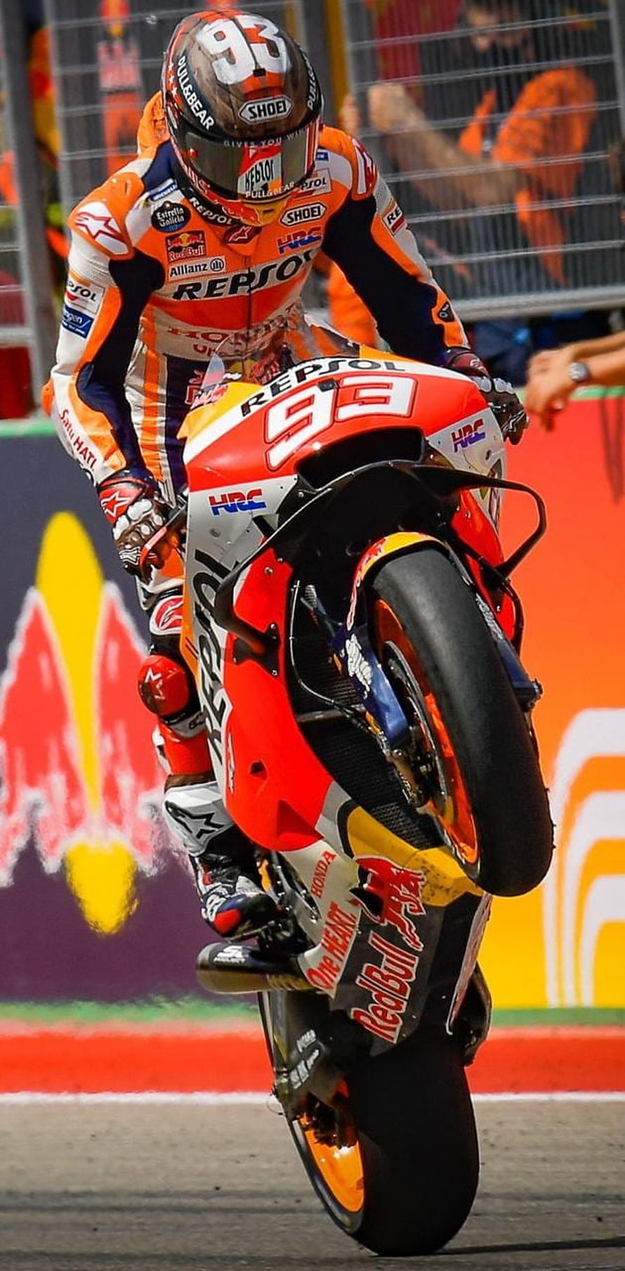 Marc Marquez performing a wheelie on his Repsol Honda RC213V motorcycle during a MotoGP race HD phone wallpaper