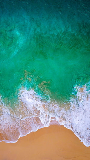 Aerial View of Turquoise Ocean Waves Crashing on Sandy Shore HD phone wallpaper