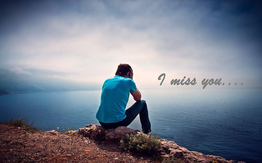 Lonely Man Sitting on Rocky Cliff Overlooking Calm Sea Under Overcast Sky HD wallpaper