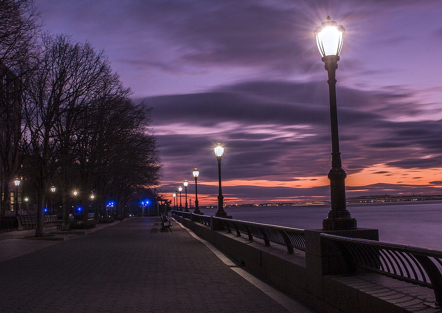 Illuminated Street Lamps Along a Waterfront Promenade at Dusk HD wallpaper