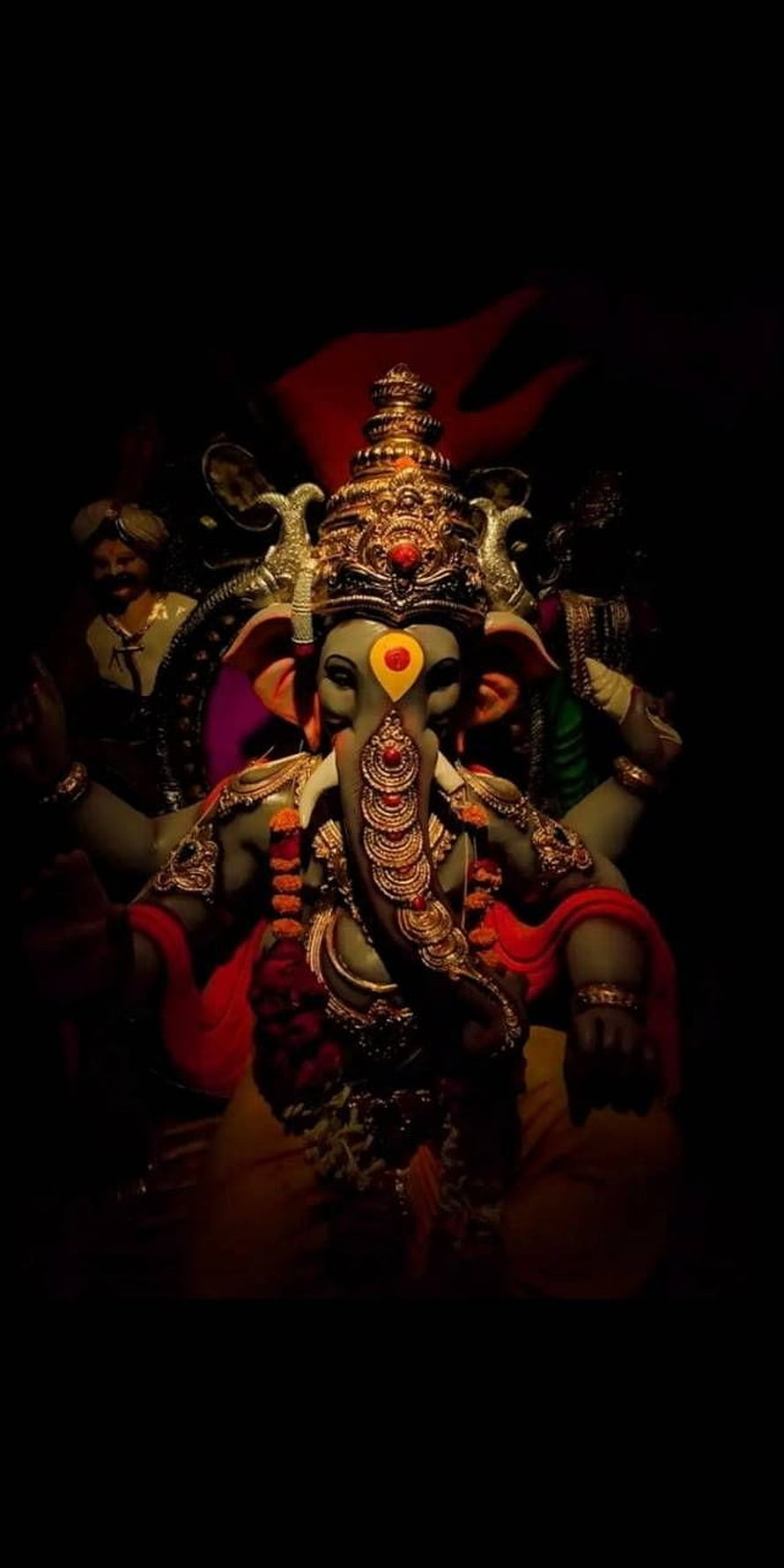 Ornate Ganesha Murti with Golden Crown and Red Garments in Dramatic Low Light HD phone wallpaper