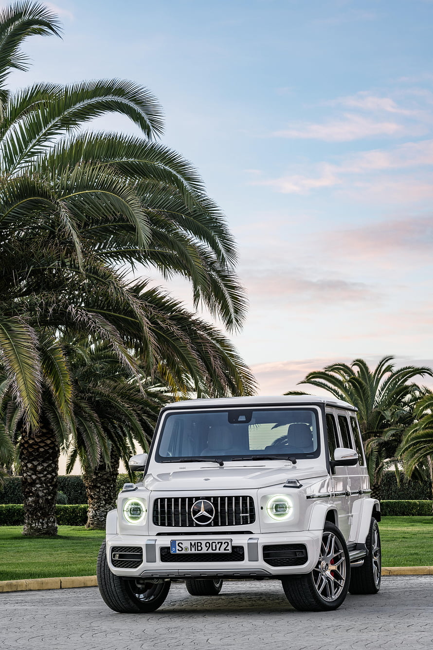 White Mercedes-AMG G63 SUV Parked on Cobblestone with Palm Trees at Sunset HD phone wallpaper