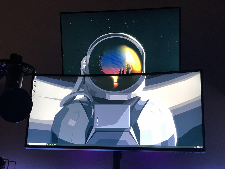 Low Poly Astronaut with Sunset Reflection in Visor on Dual Monitor Setup HD wallpaper