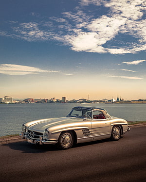 Silver Mercedes-Benz 300SL Roadster Parked on a Coastal Road at Sunset HD phone wallpaper