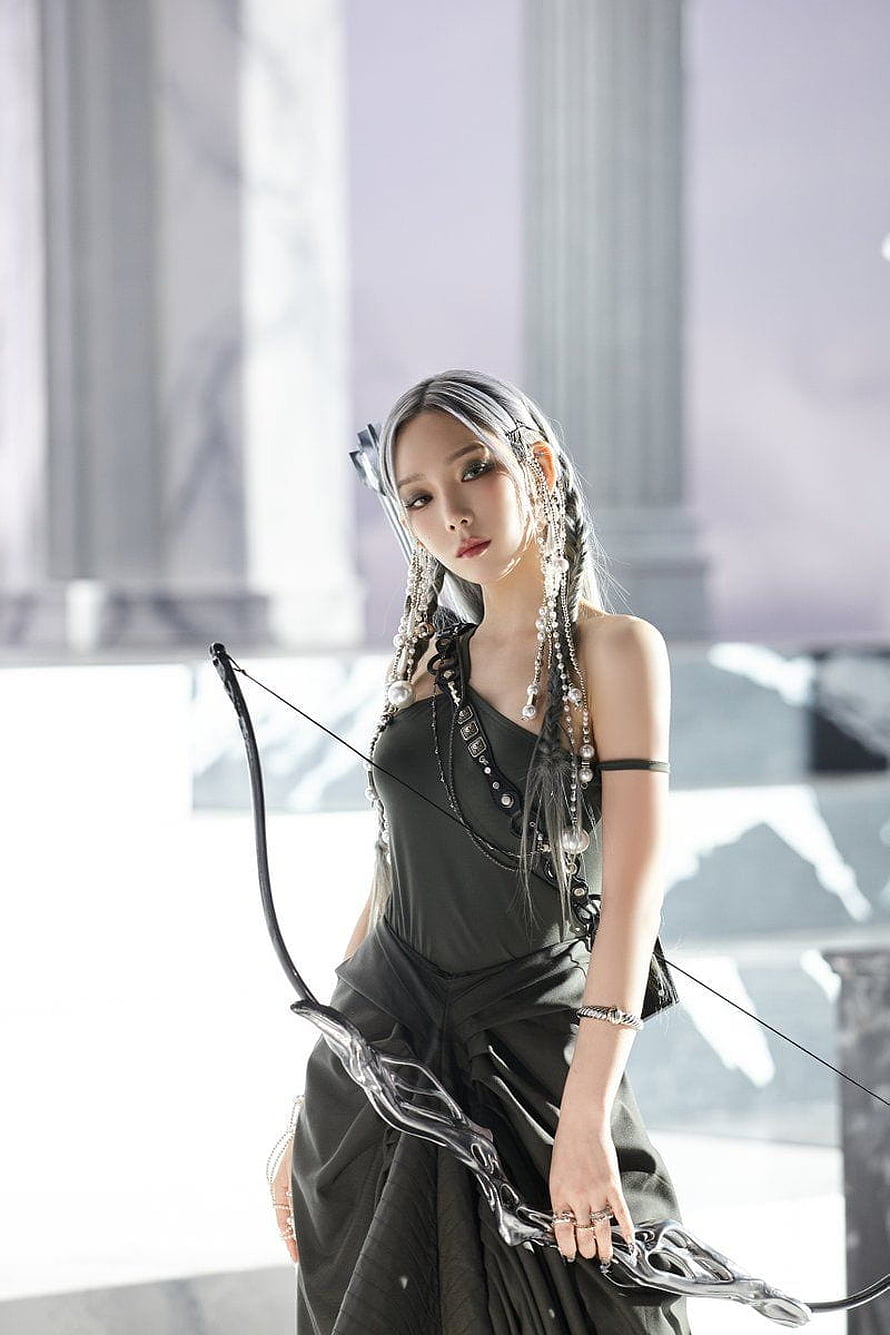 Taeyeon in a dark gothic gown holding a sculpted bow with pearl hair accessories HD phone wallpaper