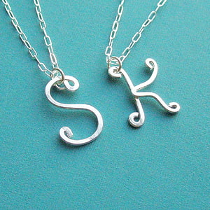 Silver Script Letter S and K Pendant Necklaces on Teal Background HD phone wallpaper