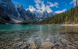 Turquoise Alpine Lake with Snow-Capped Peaks and Evergreen Forest HD wallpaper