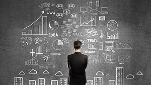 Businessman Analyzing Marketing Strategy and Growth Charts on Chalkboard HD wallpaper