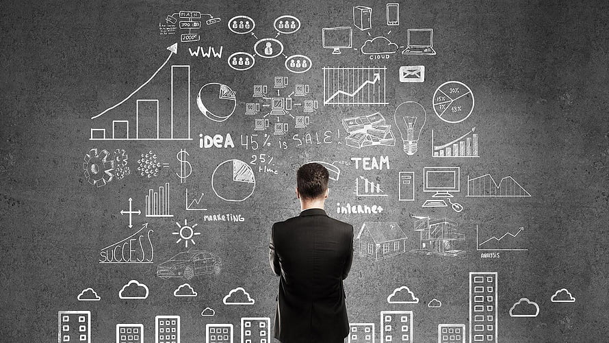 Businessman Analyzing Marketing Strategy and Growth Charts on Chalkboard HD wallpaper