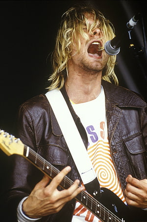 Kurt Cobain performing live with electric guitar and microphone on stage HD phone wallpaper