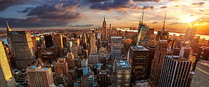 Aerial View of New York City Skyline at Golden Hour with Dramatic Clouds HD wallpaper