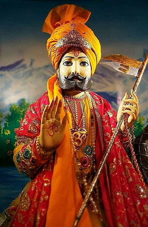 Baba Ramdev Ji Statue in Traditional Attire with Trident and Blessing Gesture HD phone wallpaper