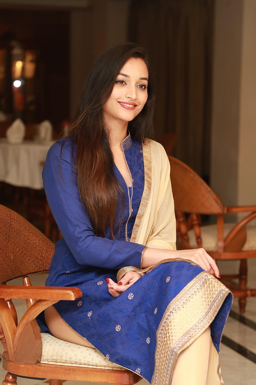 Srinidhi Shetty in a blue kurta and cream dupatta seated in a wooden chair HD phone wallpaper