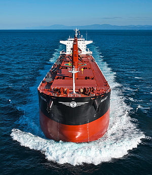 Frontal Aerial View of a Large Bulk Carrier Ship Cruising on the Open Ocean HD phone wallpaper