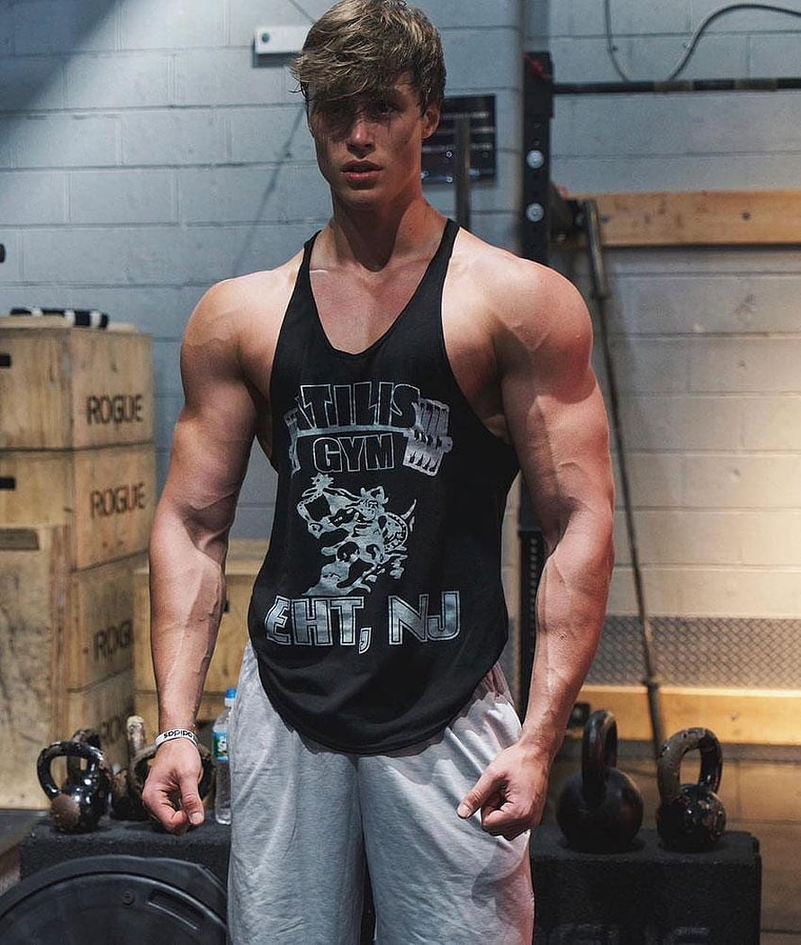 David Laid in a black tank top and grey sweatpants standing in a gym with kettlebells and Rogue boxes HD phone wallpaper