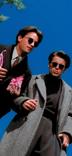 Joey and Chandler from Friends in stylish coats and sunglasses against a blue sky HD phone wallpaper