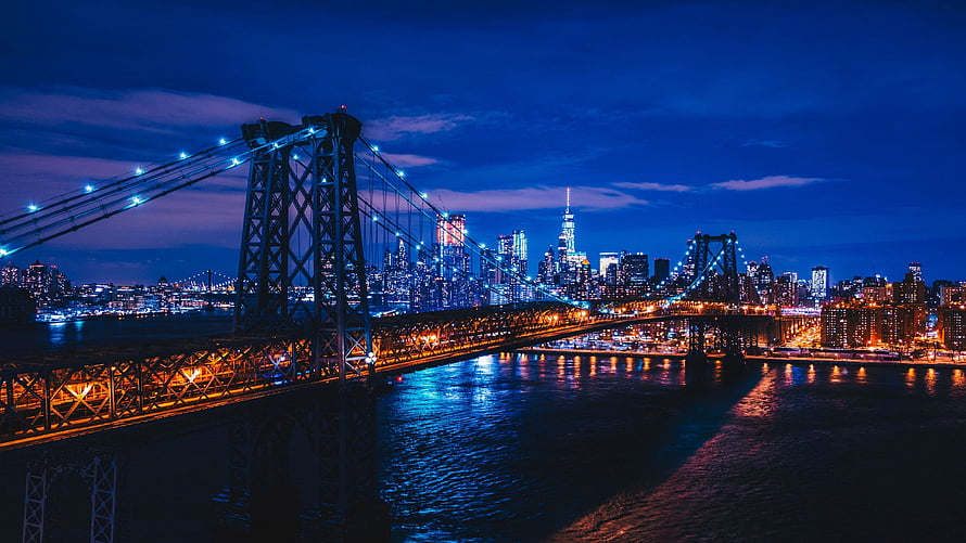 Brooklyn Bridge and Manhattan Skyline at Night with City Lights Reflecting on the East River HD wallpaper