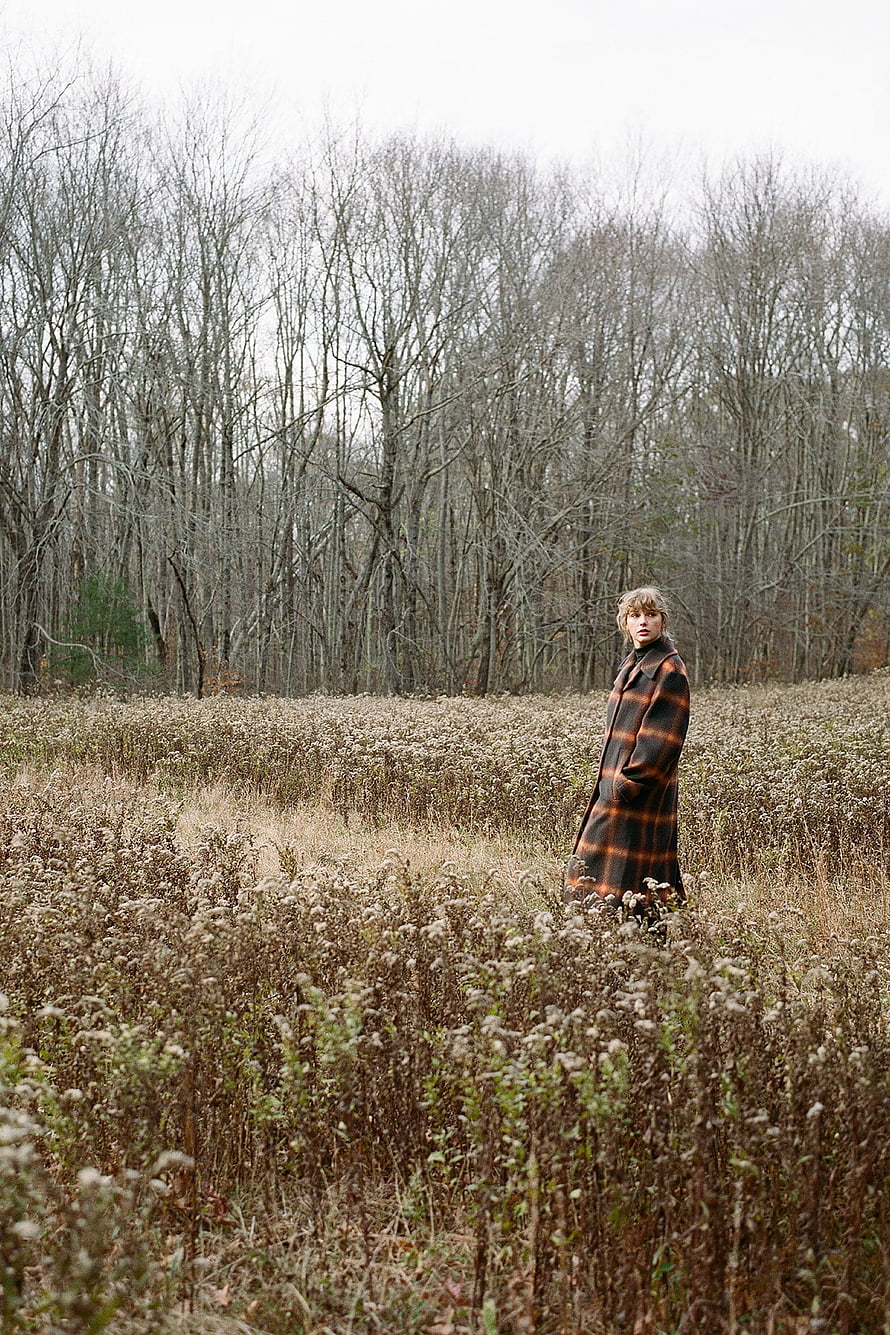 Taylor Swift in a plaid coat standing in a dry autumn field with bare trees HD phone wallpaper