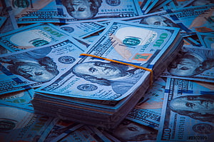 Stack of One Hundred Dollar Bills with Blue Tint and Orange Rubber Band HD wallpaper