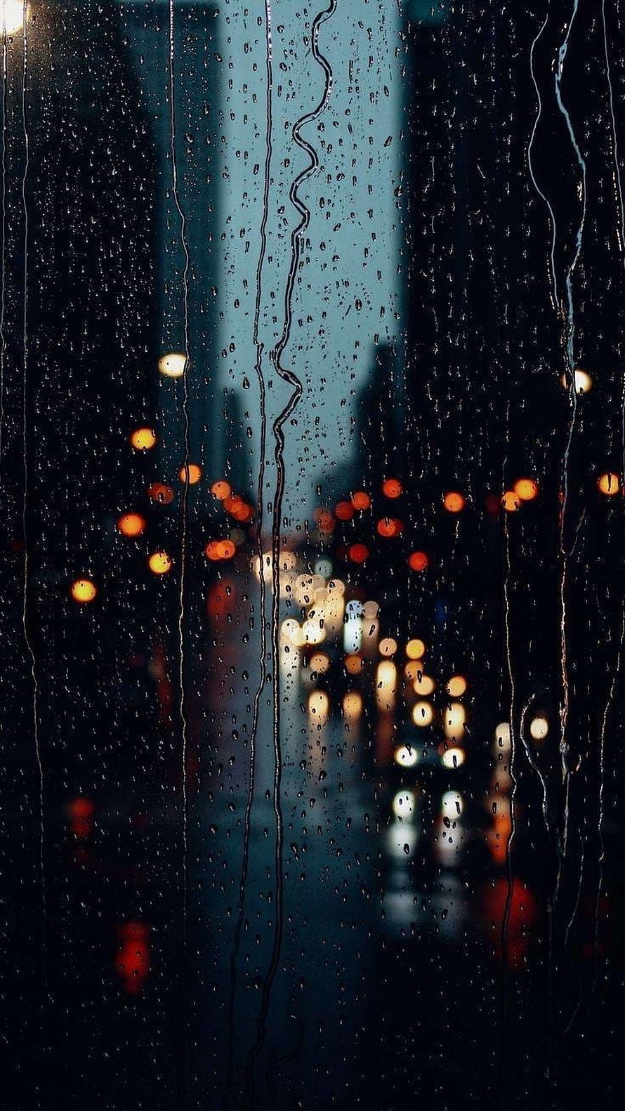 Moody Night Cityscape Viewed Through a Rain-Streaked Window with Bokeh Lights HD phone wallpaper