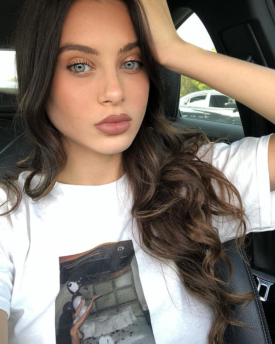 Lana Rhoades in a white graphic tee with long wavy hair, seated inside a car HD phone wallpaper
