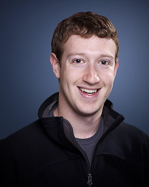 Mark Zuckerberg smiling portrait in black fleece jacket against a blue studio backdrop HD phone wallpaper