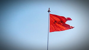 Red Bhagwa Dhwaj Flag Flying on a Tall Pole Against a Clear Blue Sky HD wallpaper