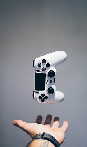 White PlayStation 4 DualShock 4 Controller Floating Above an Open Hand HD phone wallpaper