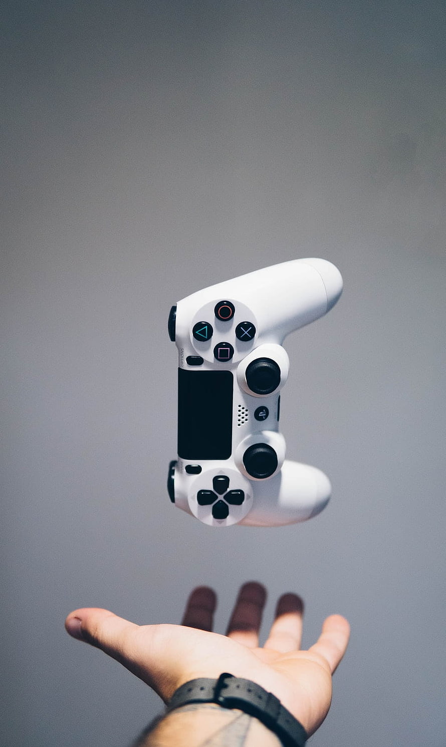 White PlayStation 4 DualShock 4 Controller Floating Above an Open Hand HD phone wallpaper