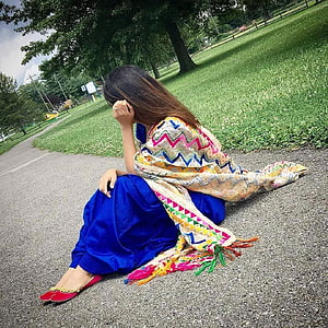 Woman in vibrant blue salwar kameez and patterned dupatta sitting on a park path HD phone wallpaper