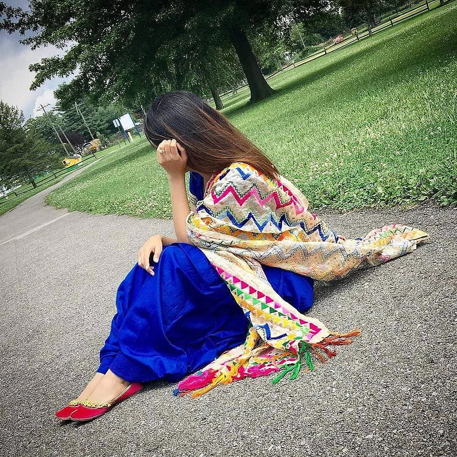 Woman in vibrant blue salwar kameez and patterned dupatta sitting on a park path HD phone wallpaper