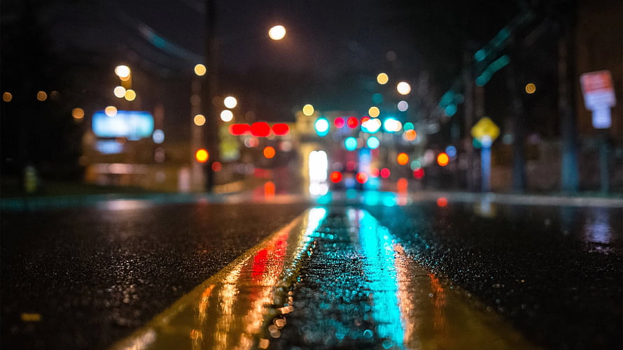 Rain-soaked city street at night with colorful bokeh lights reflecting on wet asphalt HD wallpaper