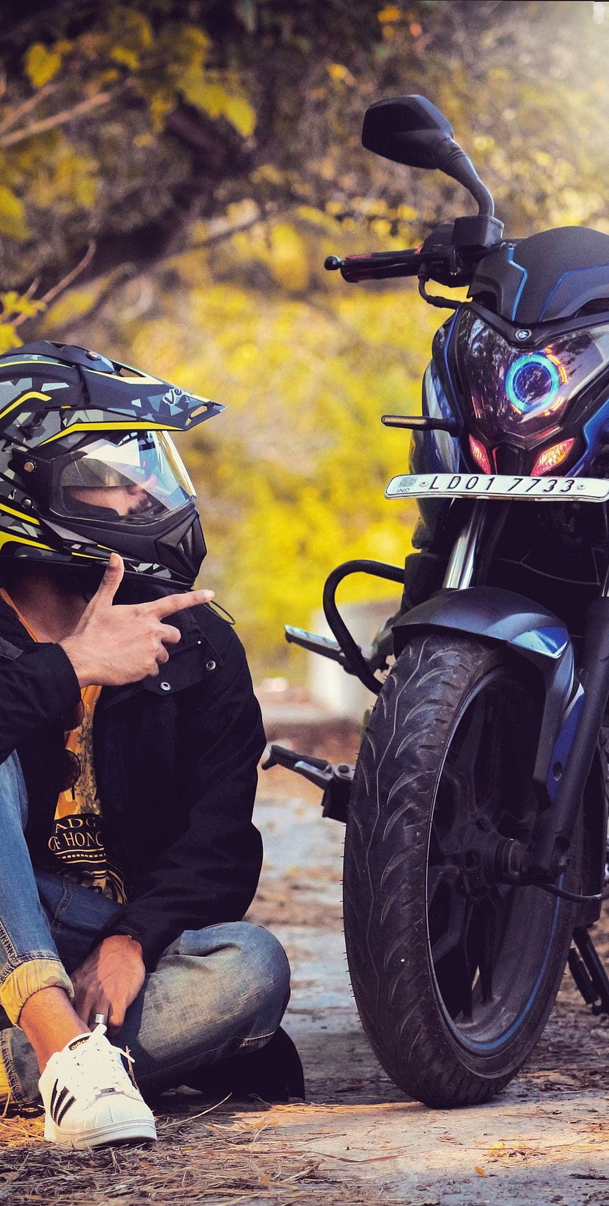 Biker Crouching Beside Pulsar NS 200 Motorcycle on a Forest Trail HD phone wallpaper