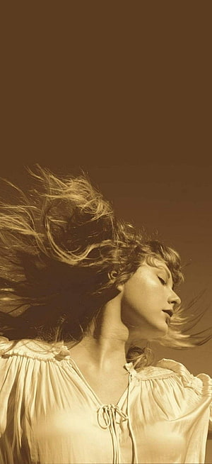 Taylor Swift in a sepia-toned portrait with windblown hair and a vintage blouse HD phone wallpaper