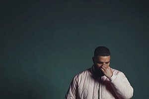 Drake in a pink puffer jacket against a dark teal studio backdrop HD wallpaper
