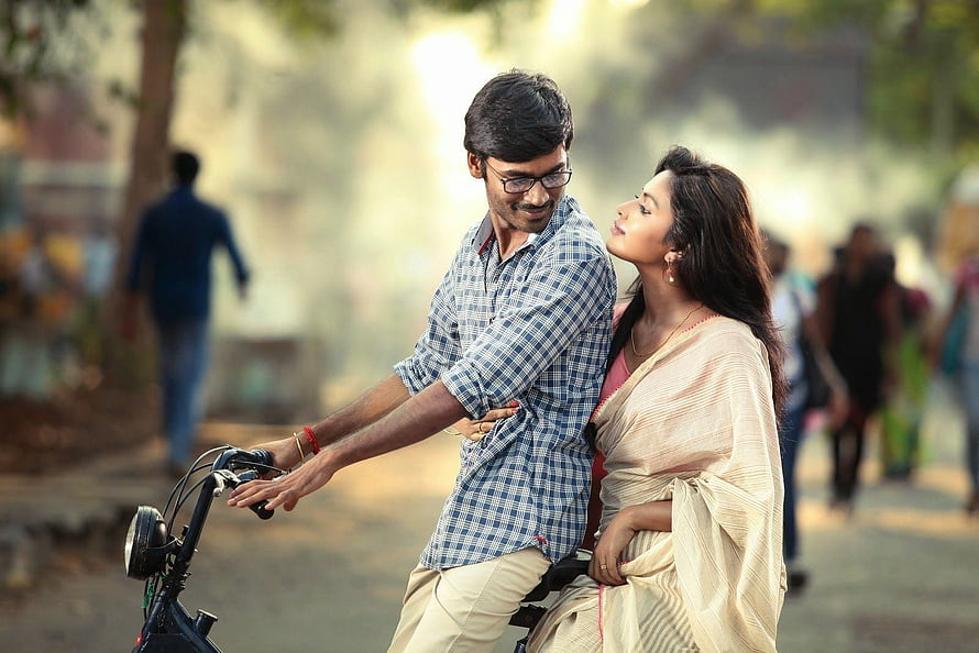 B.Tech Movie Still: Couple Sharing a Tender Moment on a Bicycle in a Sunlit Park HD wallpaper