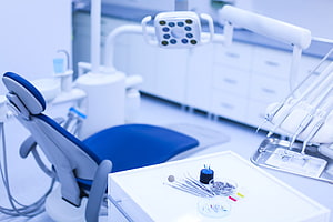 Modern Dental Clinic Interior With Blue Patient Chair And Surgical Instruments HD wallpaper