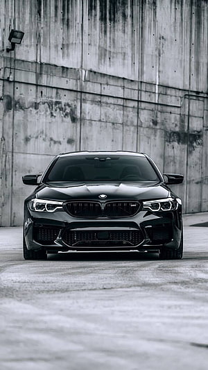 Black BMW M5 F90 Front View Against Industrial Concrete Wall HD phone wallpaper