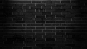 Dark Black Brick Wall Texture with Subtle Vignette and Industrial Urban Mood HD wallpaper