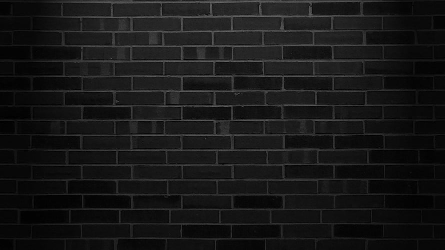 Dark Black Brick Wall Texture with Subtle Vignette and Industrial Urban Mood HD wallpaper