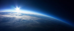 Sunrise Over Earth's Curved Horizon From Orbit With Clouds and Atmosphere Glow HD wallpaper