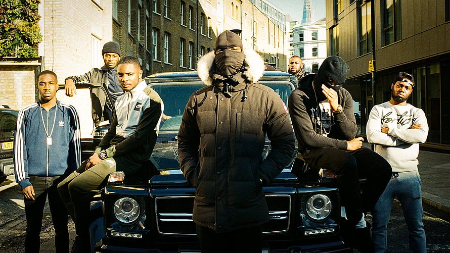 Group of men in streetwear posing around a black SUV on a London street HD wallpaper
