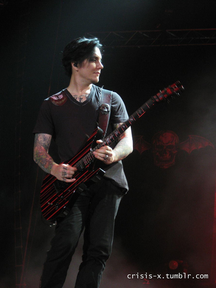 Synyster Gates performing on stage with a red and black electric guitar HD phone wallpaper