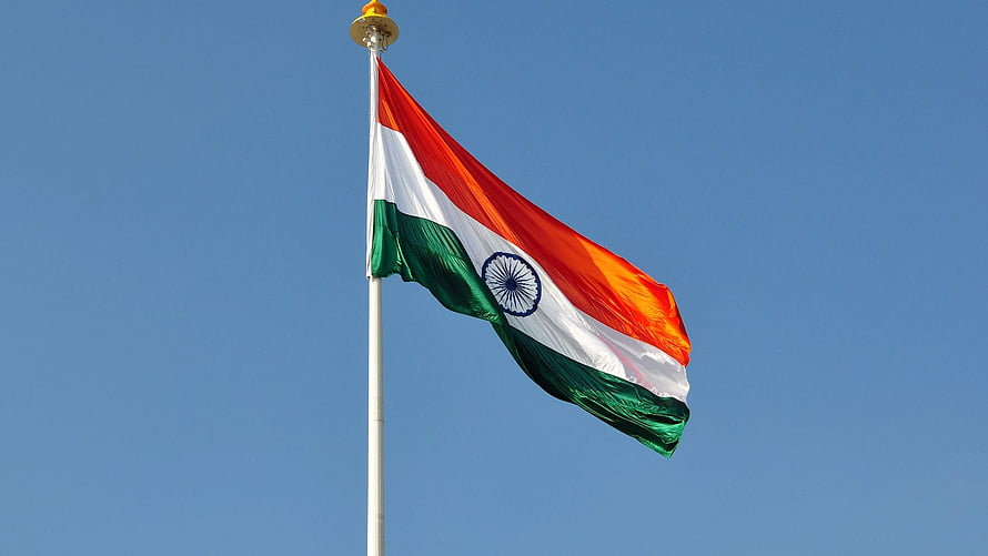 Indian National Flag Waving Against a Clear Blue Sky on a Tall Pole HD wallpaper
