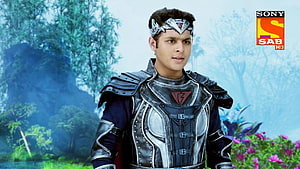 Baal Veer in ornate dark armor with silver headpiece against a misty forest backdrop HD wallpaper