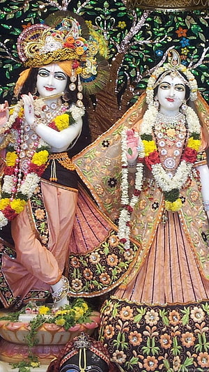 Radha Krishna Temple Deities Adorned in Ornate Garments and Floral Garlands HD phone wallpaper