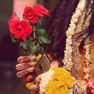 Bride in Traditional Attire Holding Red Roses and Smartphone with Intricate Henna Designs HD phone wallpaper